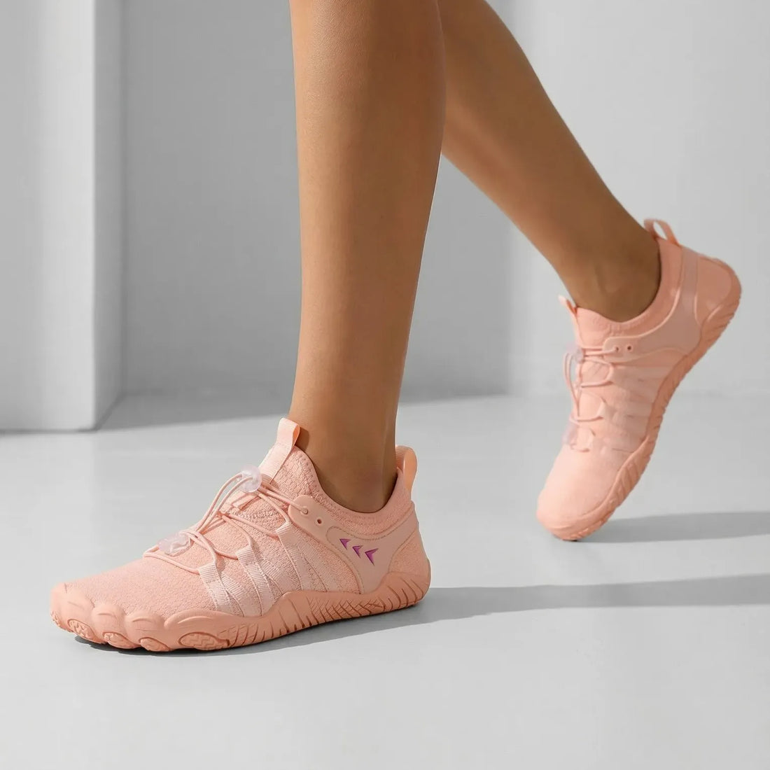 Pink quick-entry walking shoes worn on foot with stretch uppers and adjustable toggle laces
